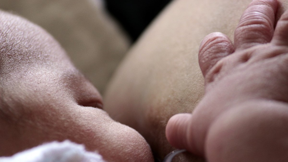 Una madre le da el pecho a su bebé.