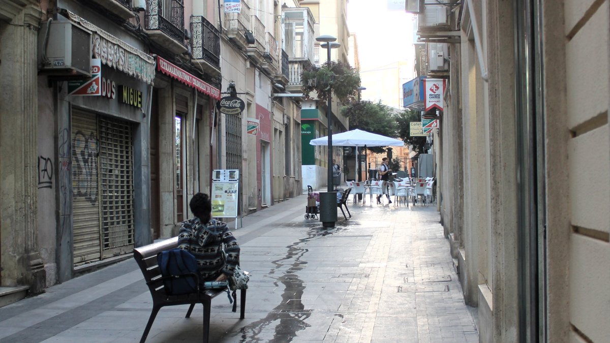 Bancos ocupados por personas sin techo y antiguos comercios que tuvieron que cerrar sus puertas.