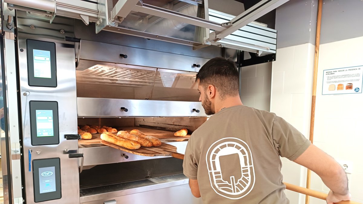 Fran Cuadrado, propietario y panadero de LaPelina, sacando el pan recién hecho del horno.