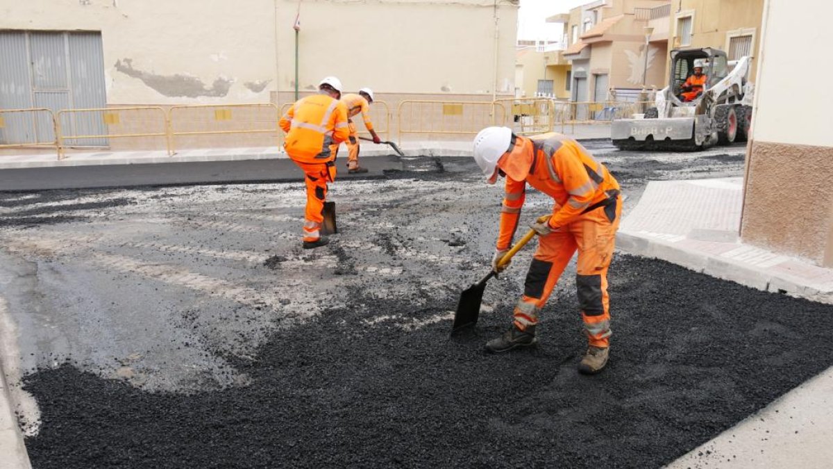 Trabajadores asfaltando la calle.