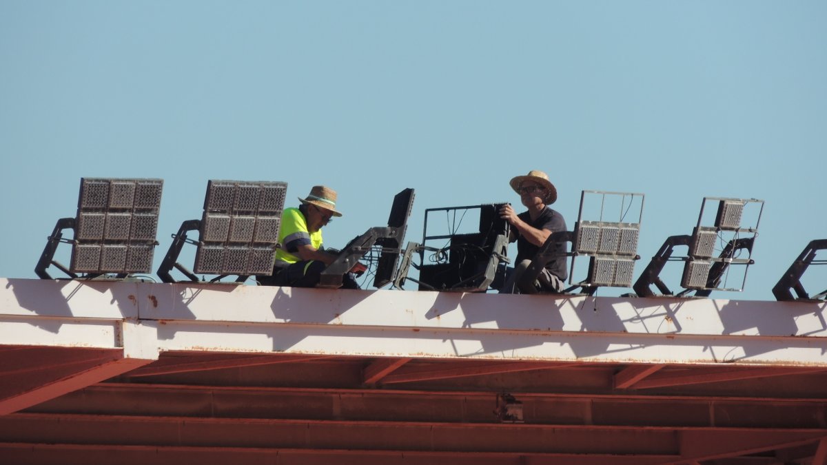 Los operarios trabajando en el techo del fondo norte para cambiar los focos fundidos.