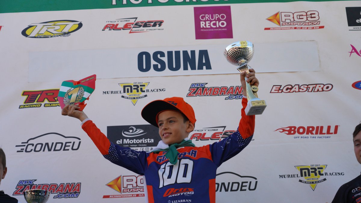 El joven piloto almeriense levanta el trofeo de ganador.