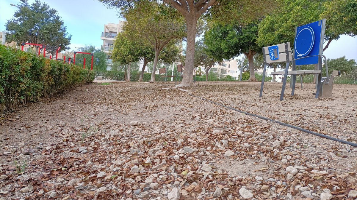 Zona con una clara pendiente y con acumulación de piedras junto a los elementos del parque biosaludable.