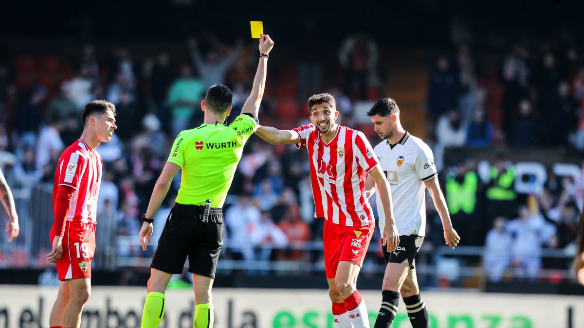 Muñiz Ruiz mostrando cartulina amarilla a Édgar González en la segunda mitad del choque.