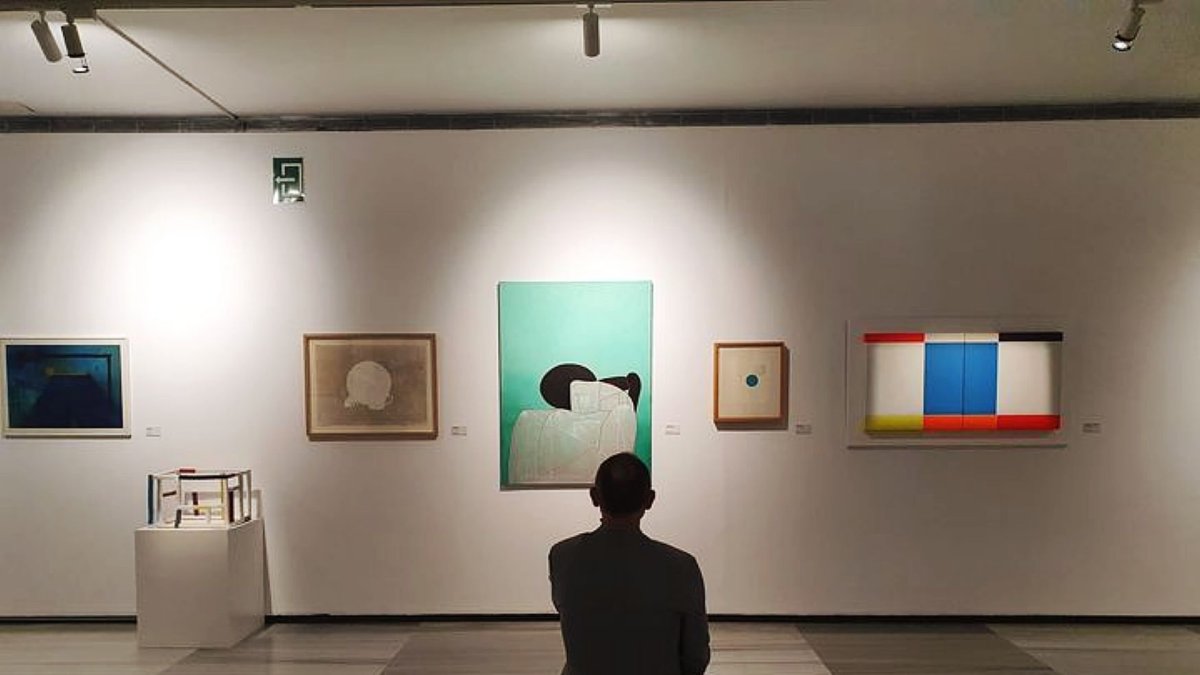 Un visitante observa las obras en la exposición.