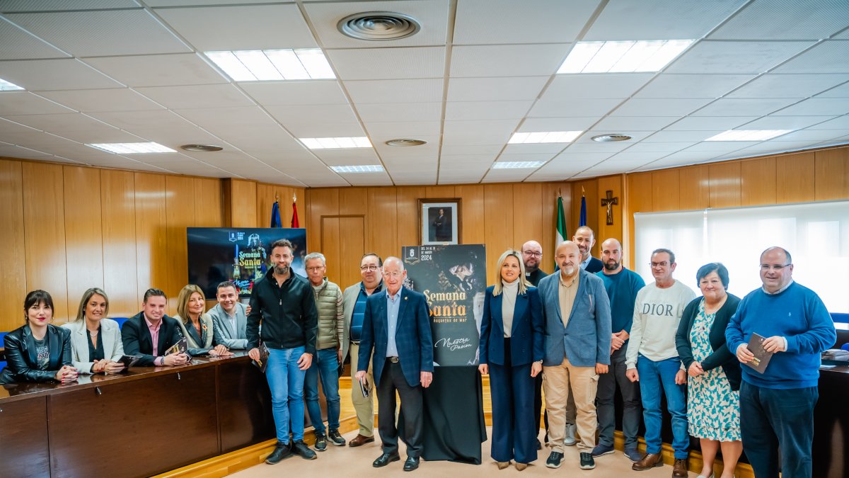 El equipo de gobierno posa con el cartel.