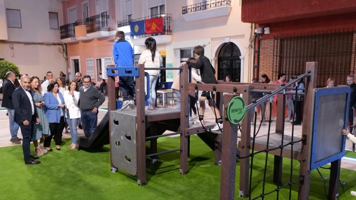 Las autoridades observando el nuevo parque en el que juegan unos niños.