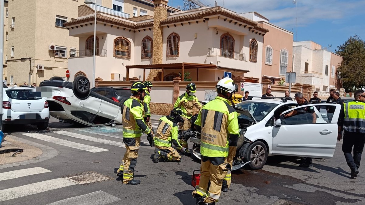 Equipo de bomberos y polícia trabajado sobre uno de los coches siniestrados.