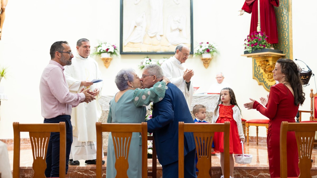 El beso más emotivo en presencia no solo de sus hijos y los sacerdotes, sino de todo un barrio.