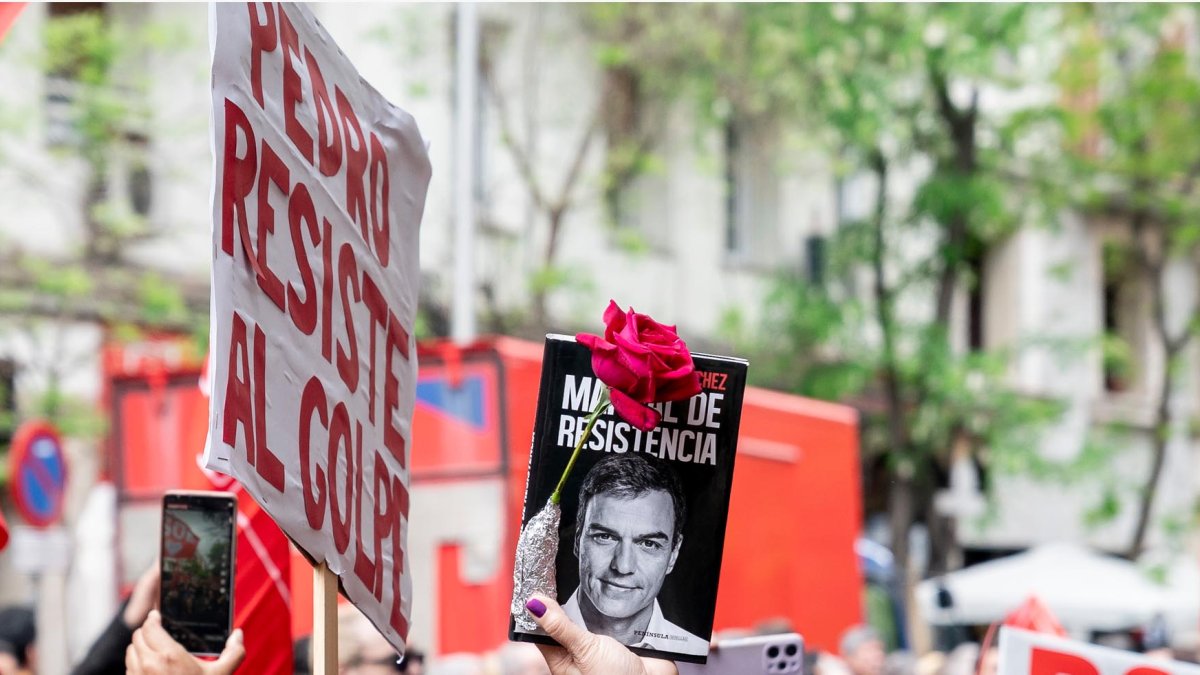Una persona sujeta un cartel durante una concentración en la calle de Ferraz en apoyo al presidente del Gobierno.
