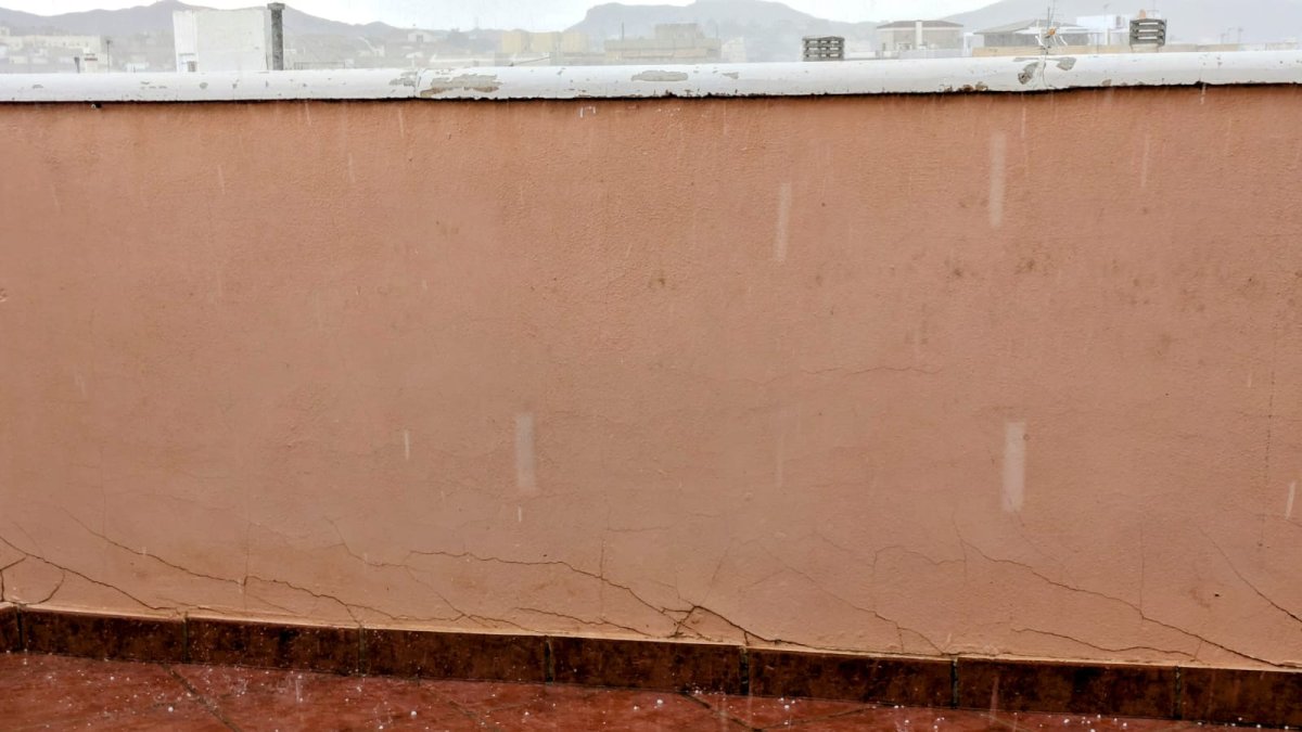 Una terraza de Albox este lunes en la que se puede apreciar el granizo durante la precipitación.