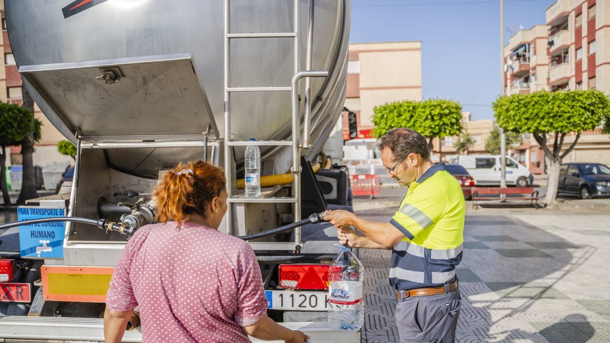 Vecina acudiendo a recibir agua potable.