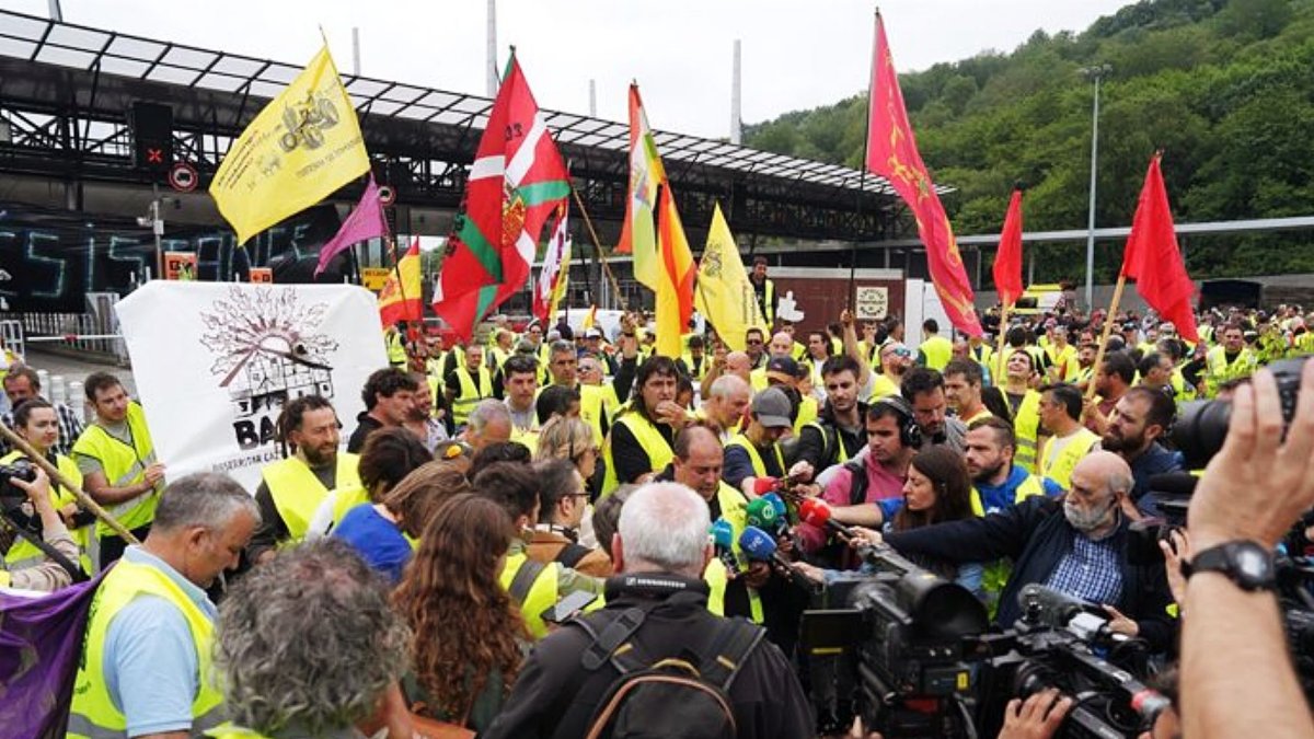 Miembros de organizaciones de agricultores ofrecen declaraciones a los medios durante una protesta en la frontera entre España y Francia.