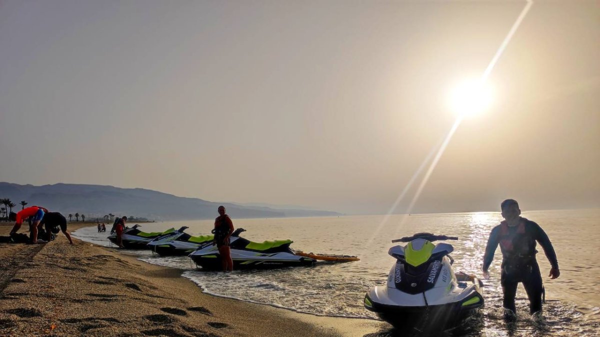 Socorristas a la orilla de la playa junto a sus motos de agua.