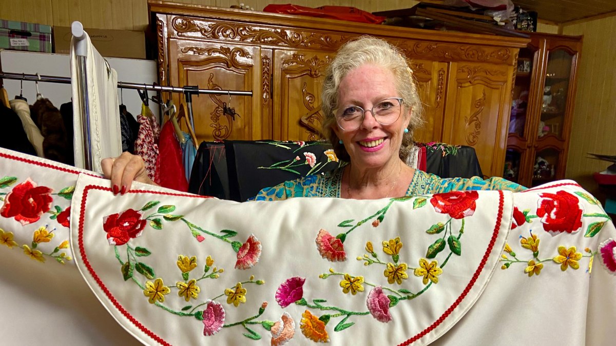 La artista bordadora Ana Morel, sujetando uno de sus capotes de paseo para toreros.
