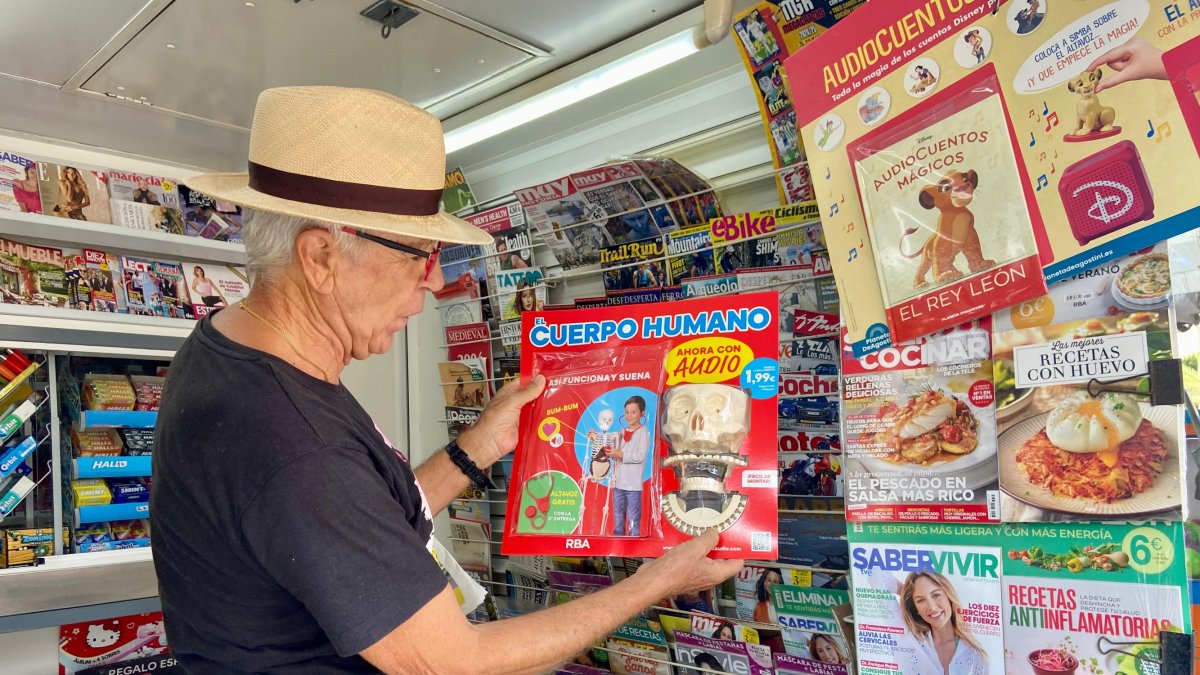 Pepe Alonso, cliente habitual del quiosco de Antonia Olivares, mirando el coleccionable \'Cómo funciona el cuerpo humano\'.