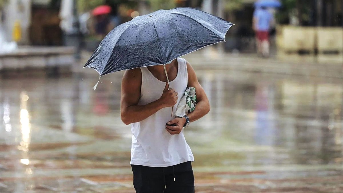 Imagen de archivo de un almeriense protegiéndose de la lluvia con un paraguas.