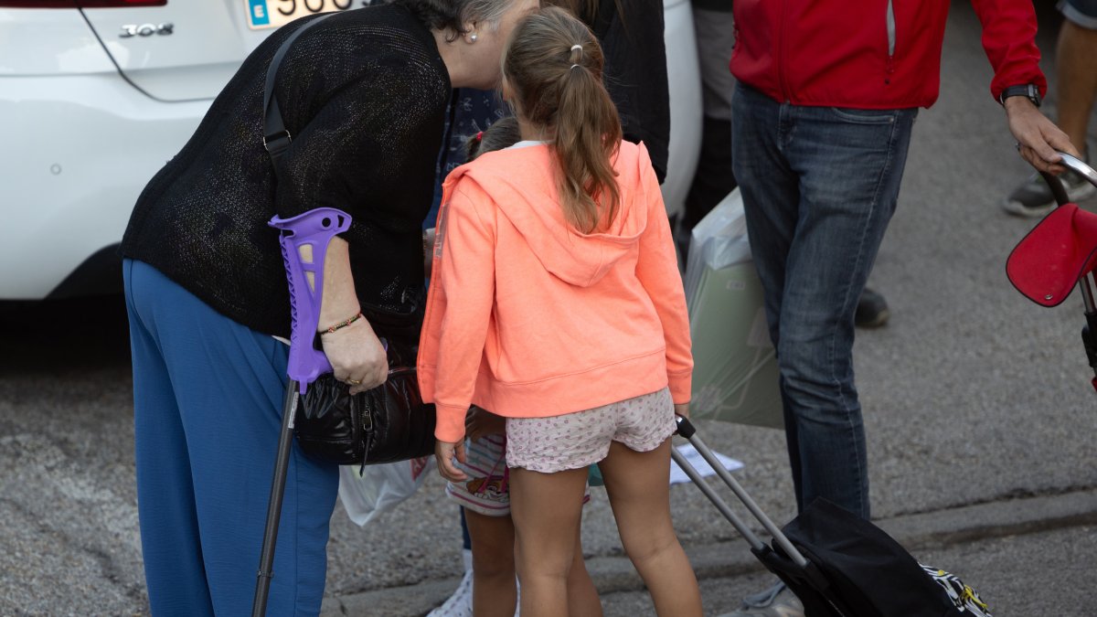 Una niña se despide de su abuela el primer día de colegio.