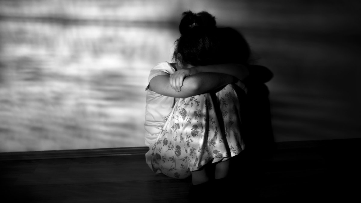 Concepto de ansiedad infantil, niña pequeña sentada en el suelo.