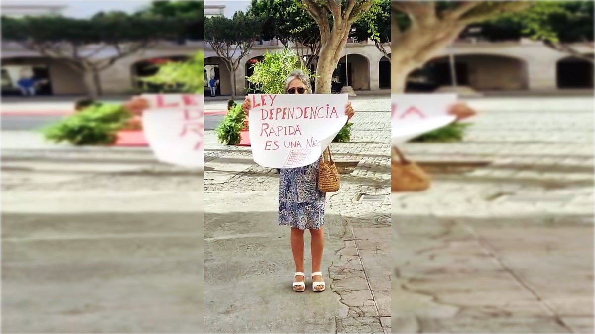 María del Rosario Romero, madre de Marina, mostrando un cartel reivindicativo.