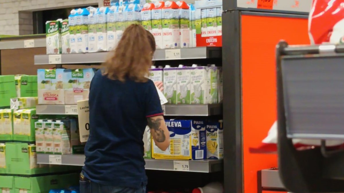 Una trabajadora de un supermercado cambia las etiquetas de los precios de los alimentos.