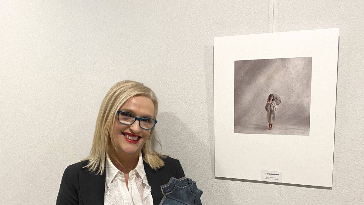 La fotógrafa junto a la imagen y con el galardón logrado.