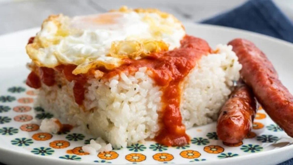 Un plato de arroz con huevo frito y salchichas. DEPOSITPHOTOS