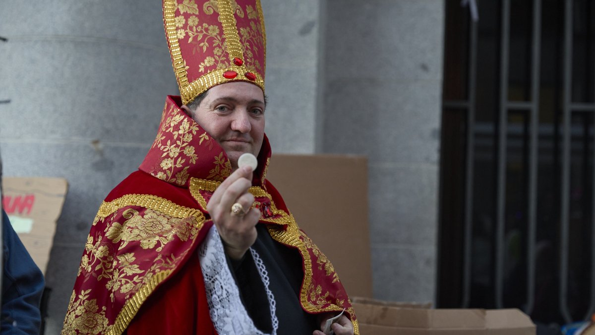 Una persona disfrazada hace cola para entrar en el Sorteo de Navidad en el Teatro Real.