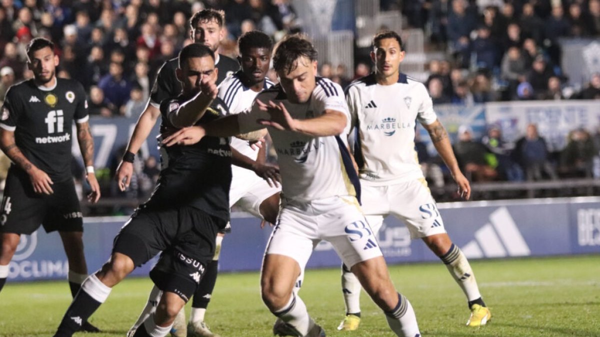 Dani Romera de negro luchando contra la defensa del Marbella.