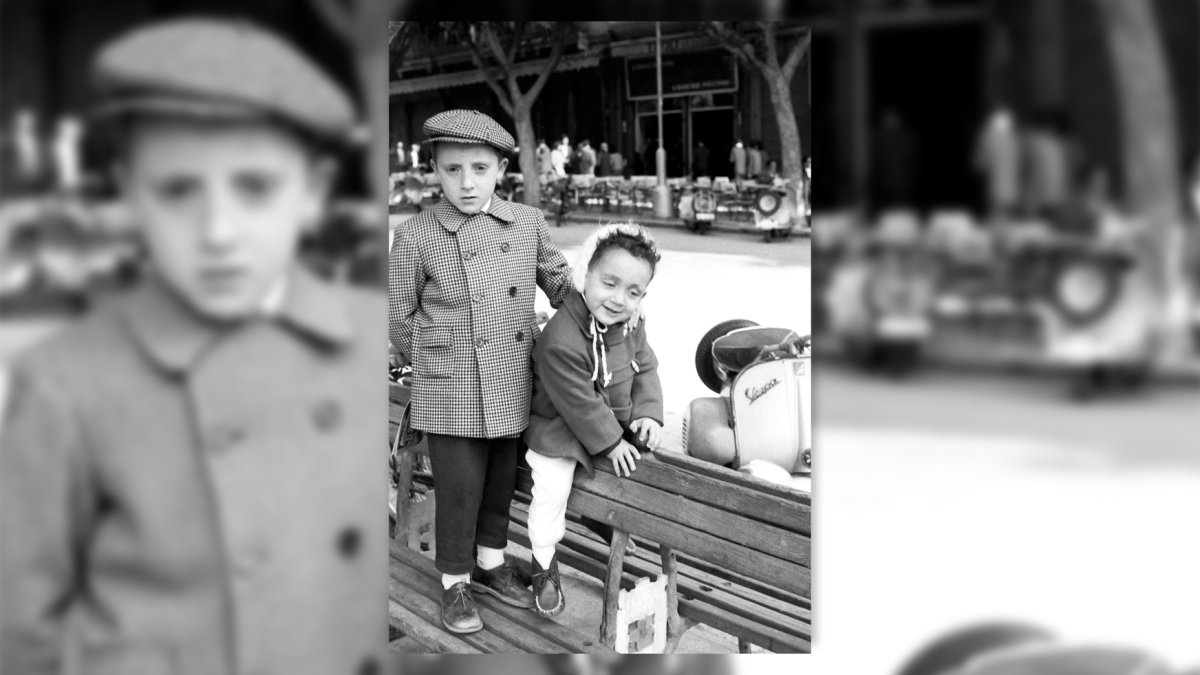 Los hermanos Carrión jugando en uno de los bancos antiguos de hierro y madera que había en el Paseo. Años 60.