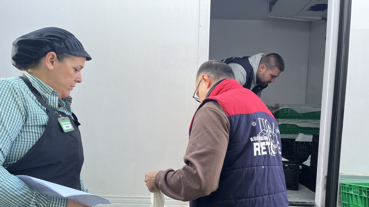 Una trabajadora de Mercadona ayuda a cargar los alimentos donados por la empresa.