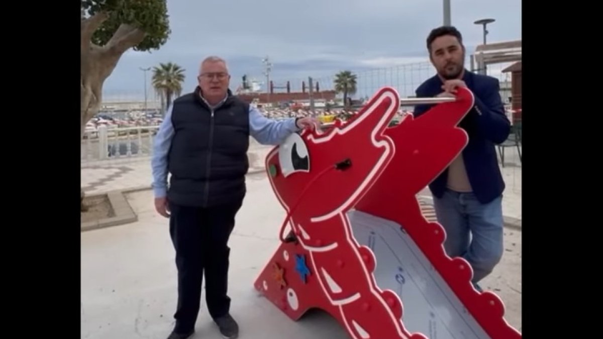 El alcalde y el teniente de alcalde junto al rocódromo infantil y tobogán.