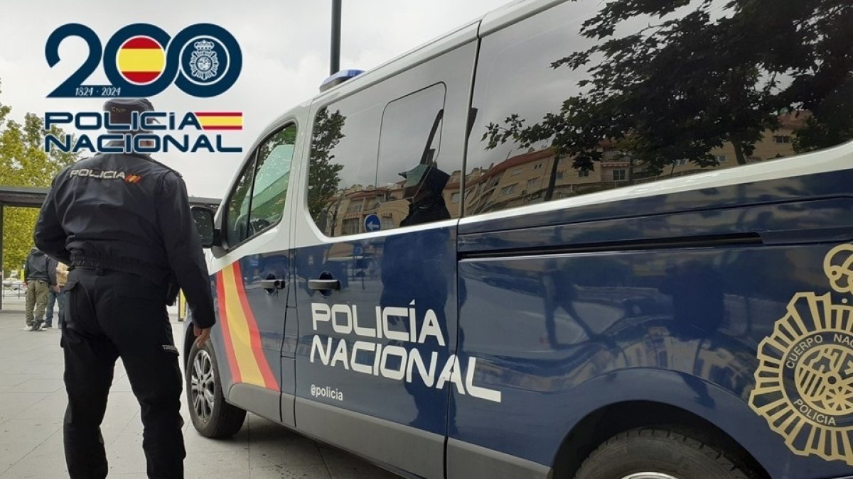 Agente de la Policía Nacional junto a un furgón.