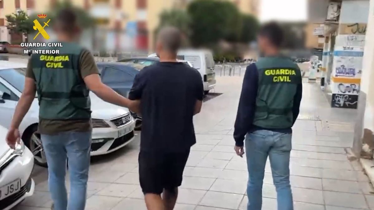 Dos agentes de la Guardia Civil escoltan al hombre detenido por difundir mensajes de odio en Internet.