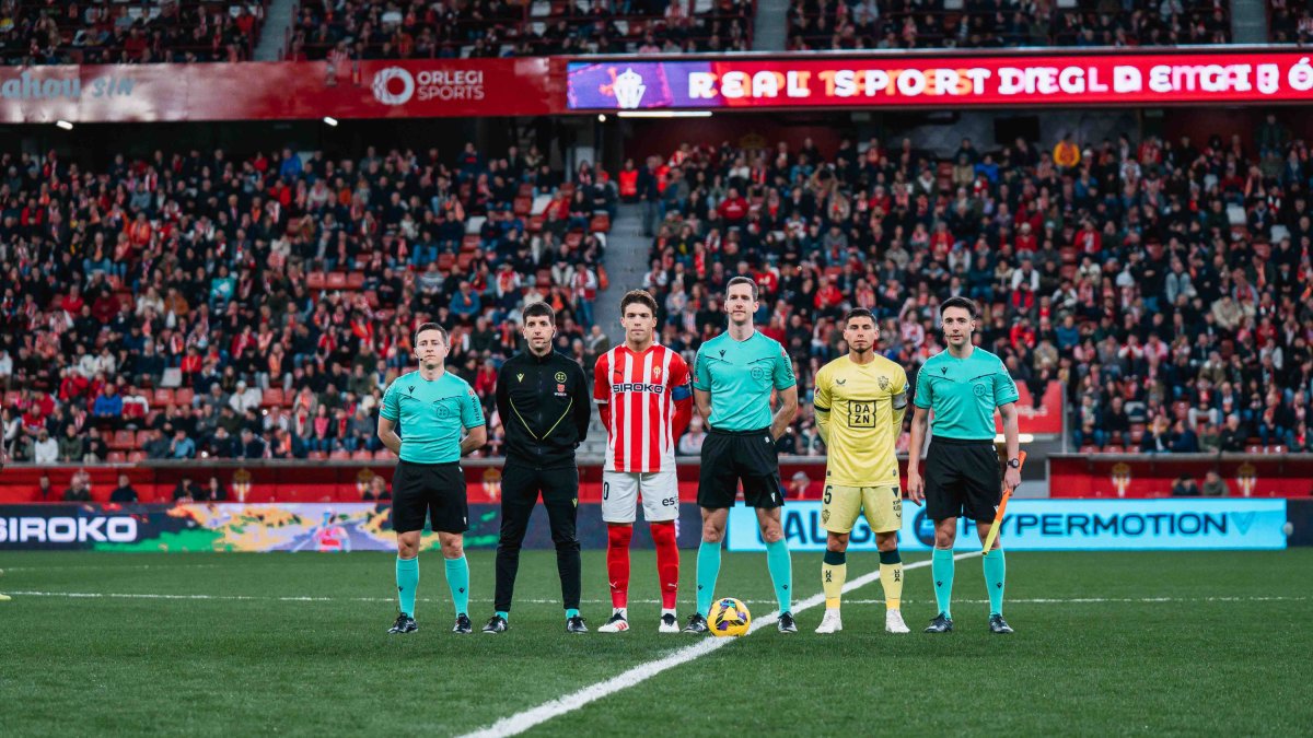 El equipo arbitral con los capitanes en el Sporting-Almería.