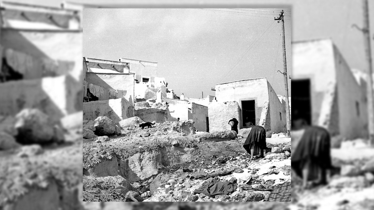Una mujer buscando algo de valor entre la ropa vieja y la basura en una cuesta de los cerros de La Chanca.