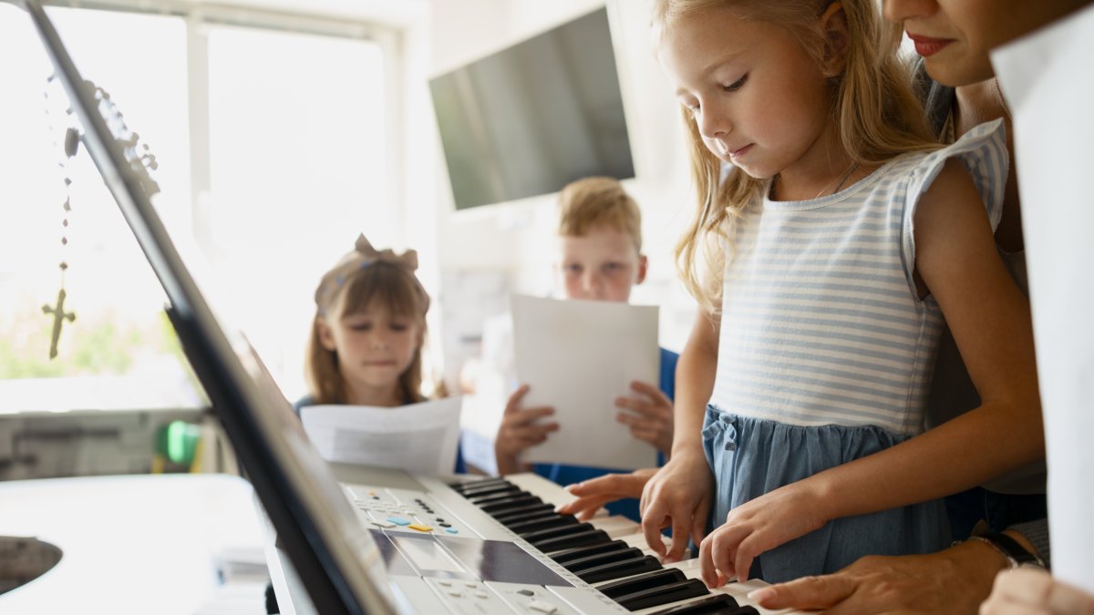 Una niña aprende a tocar el piano.