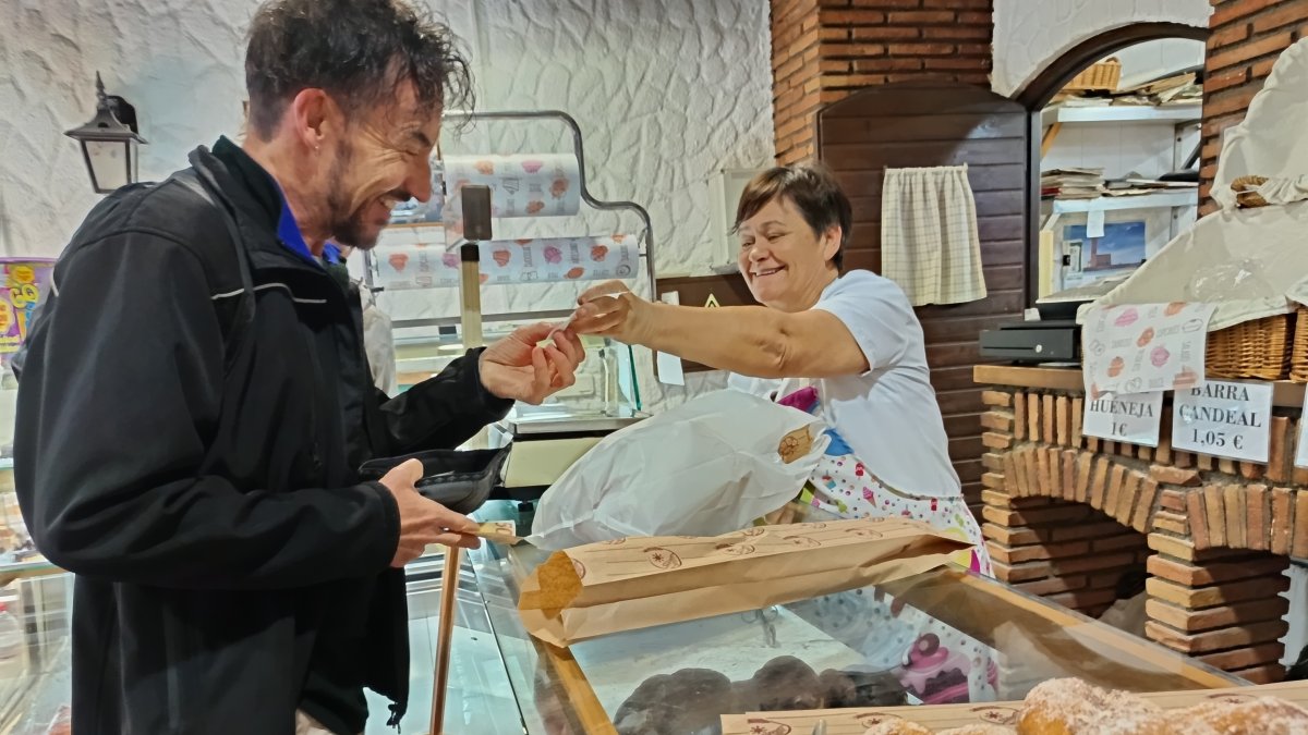 Isabel atiende a un cliente en su negocio de panadería y dulces caseros de Calle San Miguel.