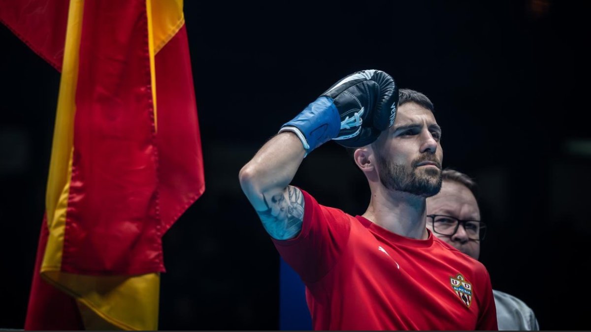 La bandera, el himno de España y su camiseta con el escudo del Almería.