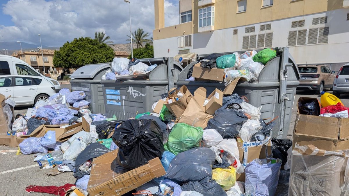Contenedores repletos y basura en la vía.