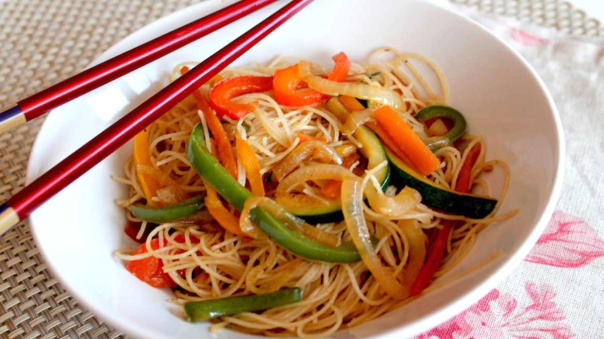 Un plato de fideos de arroz salteados con verduras.