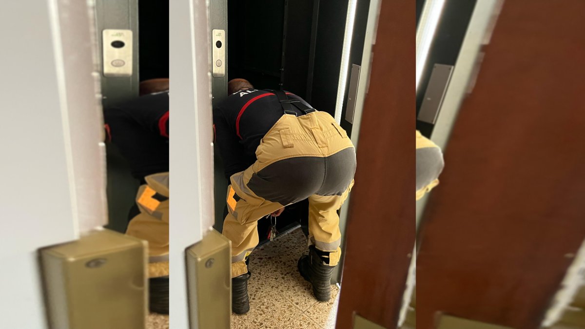 Un bombero trabaja en el ascensor donde quedó atrapada la mujer.