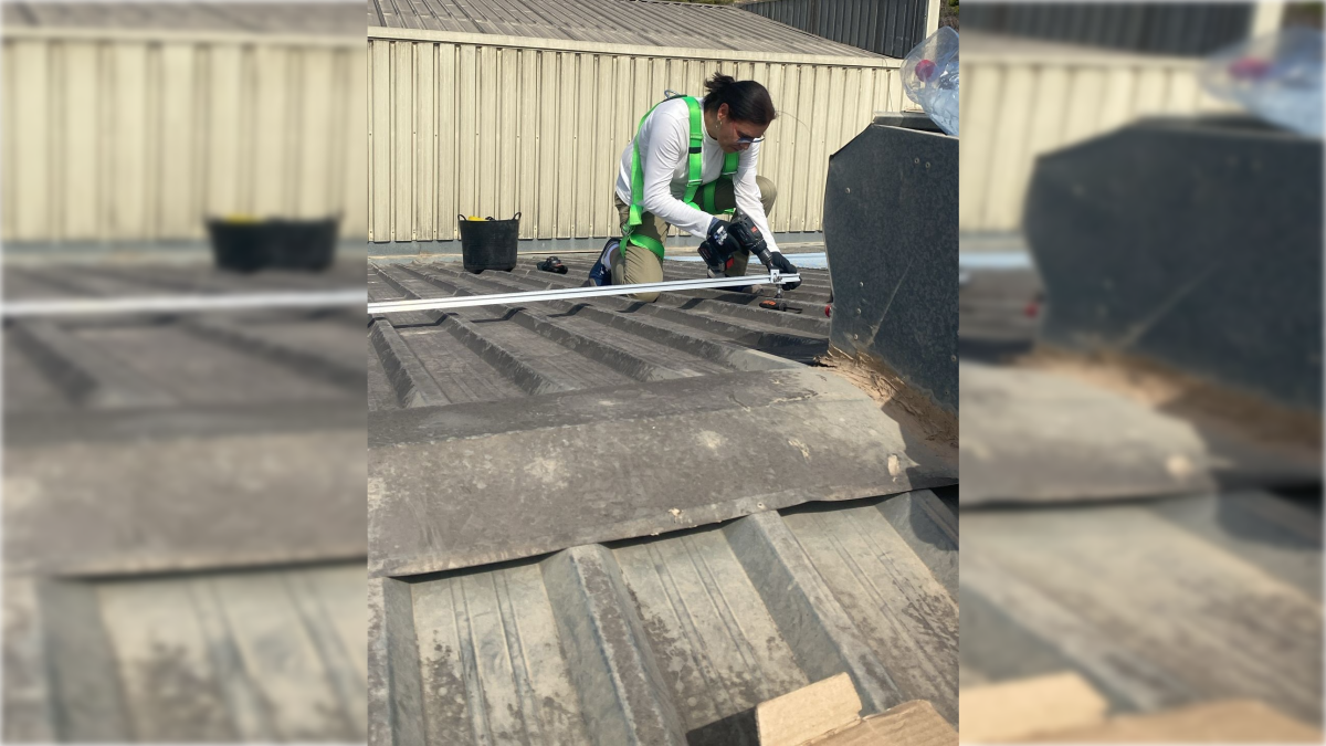 Una mujer aprende a instalar una placa fotovoltaica.