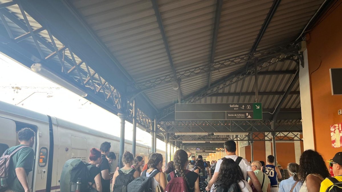 Viajeros esperan para subir al bus tras cancelarse el viaje en tren
