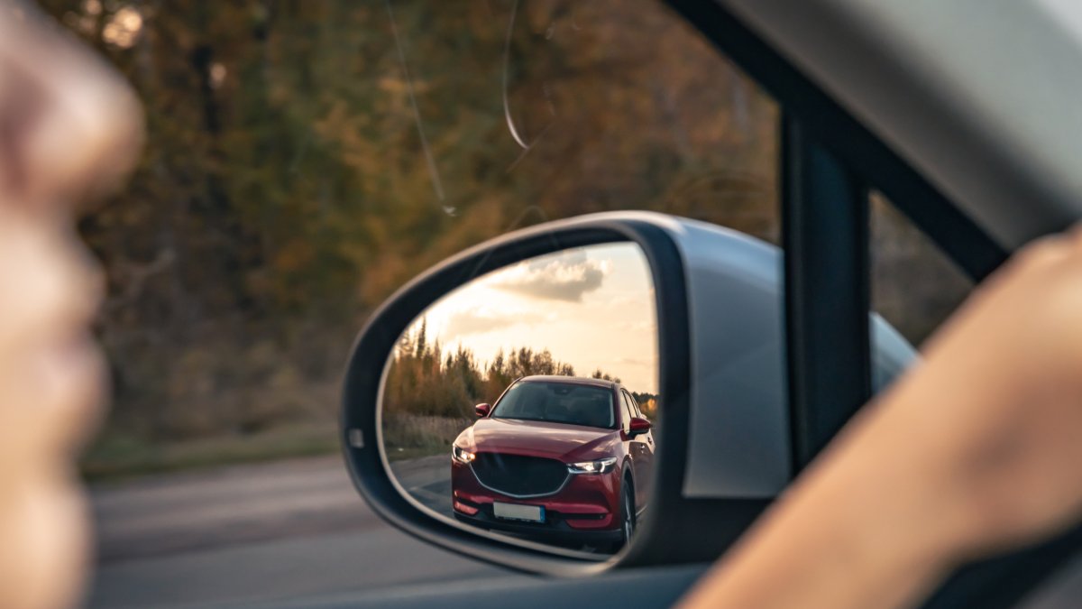 Vista de la carretera desde el espejo retrovisor de un vehículo.