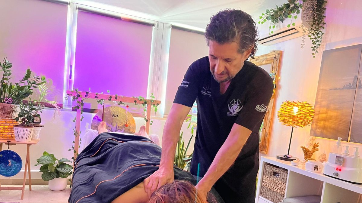 Manuel Romera atendiendo a una cliente en su consulta frente al mar.