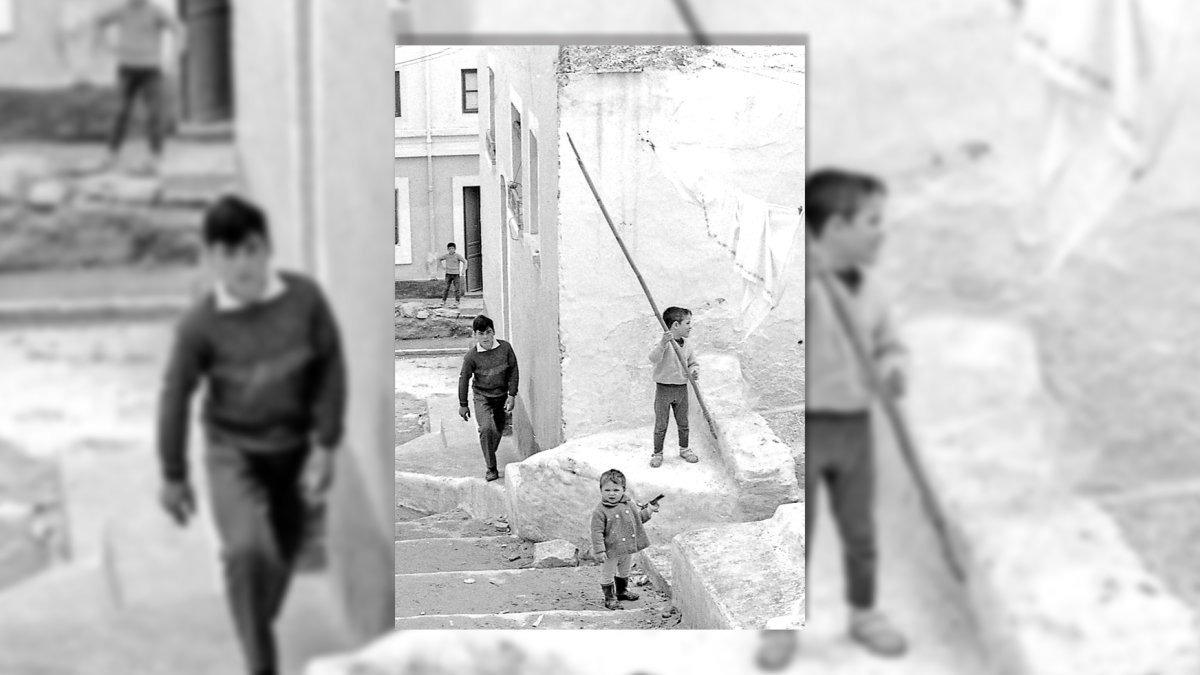 Un niño de la calle Valdivia con una pistola de juguete en la mano, junto a otro que coge el palo de madera de sujetar la ropa tendida como si fuera una lanza.