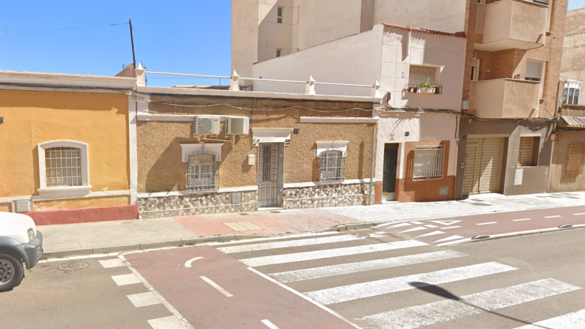 En el centro, vivienda en la que se ha producido el crimen que ha acabado con la vida de una mujer en Almería.