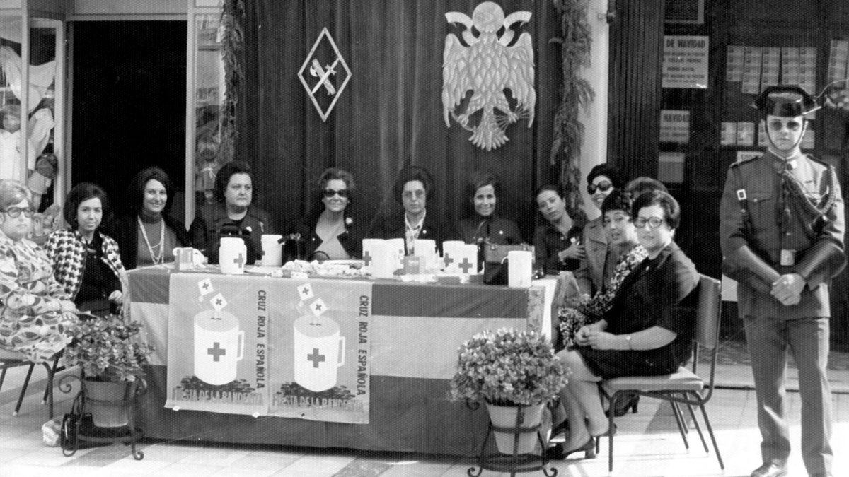 Mesa del día de la banderita para pedir contra el cáncer en el Paseo, entre el despacho de lotería y la tienda de la Giralda. Años 60.