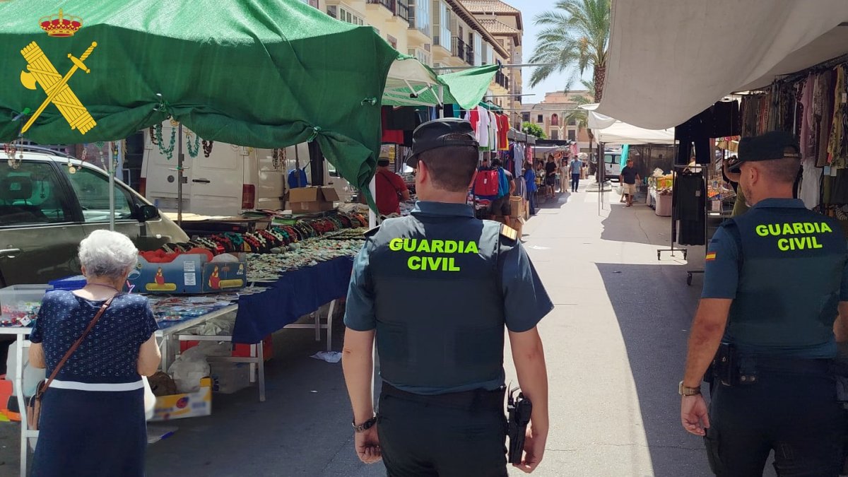 Dos agentes de la Guardia Civil patrullan en un mercadillo de Almería.